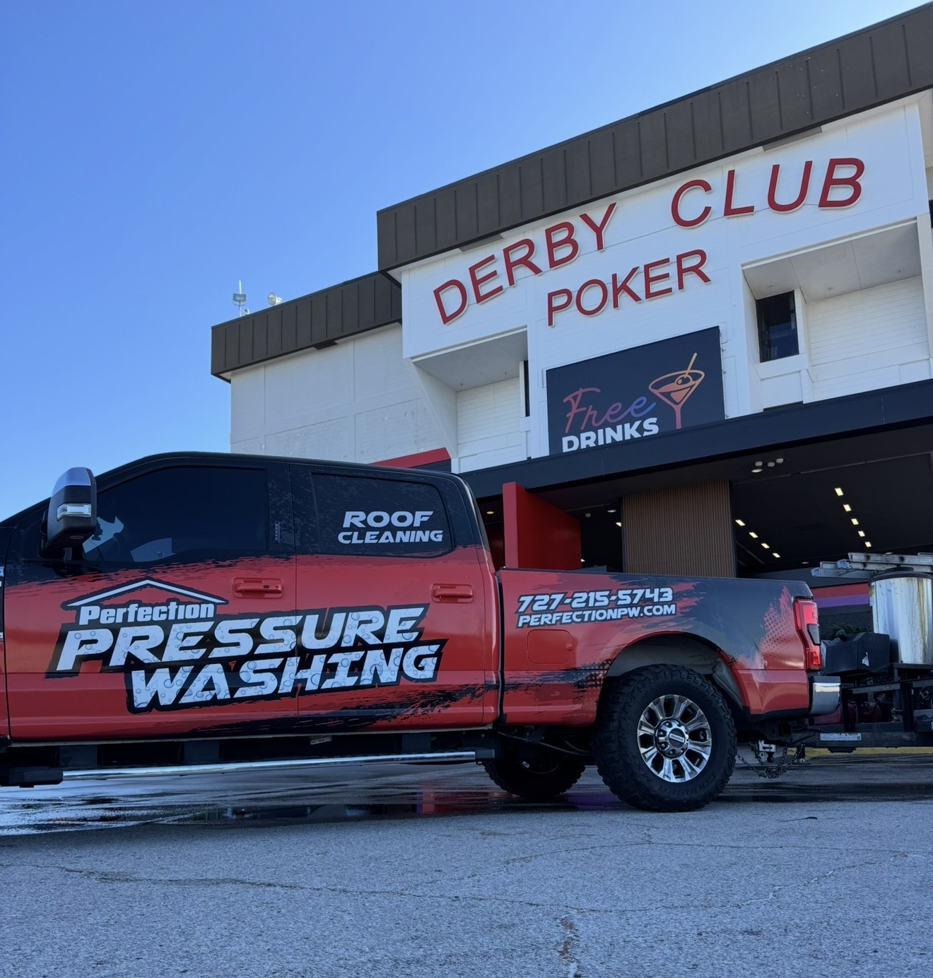 Perfection Pressure Washing truck and equipment trailer set up at a commercial job site